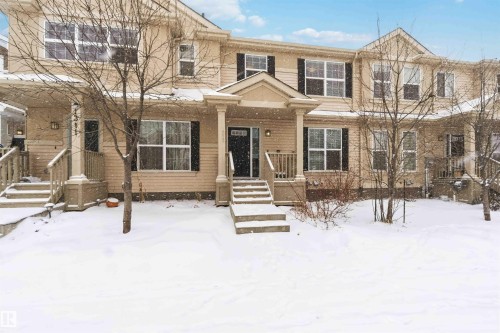 The property features a multi-story exterior with light-colored siding and dark window shutters - 1313 Chappelle Boulevard, Edmonton, AB - Outdoor With Facade