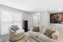 This inviting living space features light gray walls, a large window with blinds, and light-toned flooring - 1313 Chappelle Boulevard, Edmonton, AB  - Indoor Photo Showing Living Room 