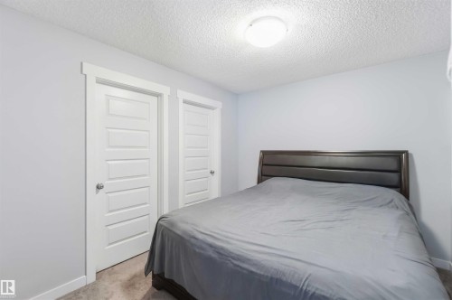 This room features light-colored walls, white paneled doors, and a neutral-toned carpet - 1313 Chappelle Boulevard, Edmonton, AB - Indoor Photo Showing Bedroom