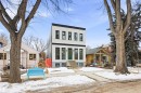 The property features a modern white facade with contrasting black trim and numerous windows, set back from a sidewalk and street - 9807 90 Avenue, Edmonton, AB  - Outdoor With Facade 