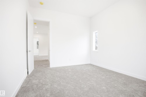 This room features light grey carpeting, white walls, and a recessed ceiling light - 9807 90 Avenue, Edmonton, AB - Indoor Photo Showing Other Room