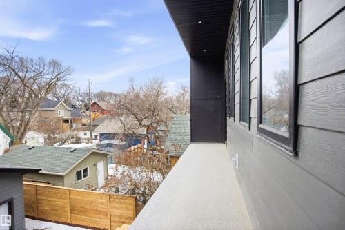 The property features an exterior with gray siding and black-framed windows, complemented by a covered outdoor area - 9807 90 Avenue, Edmonton, AB - Outdoor With Exterior