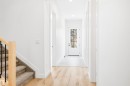 Entryway featuring a light wood floor, a white door with glass panels, and a staircase with light wood banister and black metal spindles - 9807 90 Avenue, Edmonton, AB  - Indoor Photo Showing Other Room 