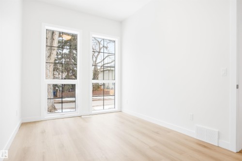 This room features light-toned flooring and white walls, creating a bright and airy atmosphere - 9807 90 Avenue, Edmonton, AB - Indoor Photo Showing Other Room