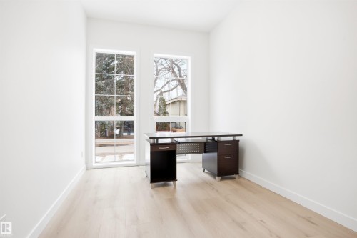 This room features light-colored flooring and white walls, creating a bright and airy atmosphere - 9807 90 Avenue, Edmonton, AB - Indoor Photo Showing Other Room