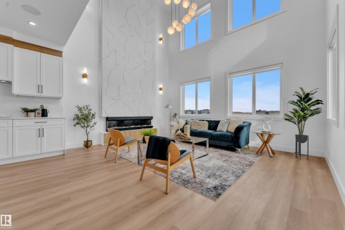 Expansive living area with high ceilings, large windows, and light wood flooring - 110 Eldridge Point(E), St. Albert, AB - Indoor