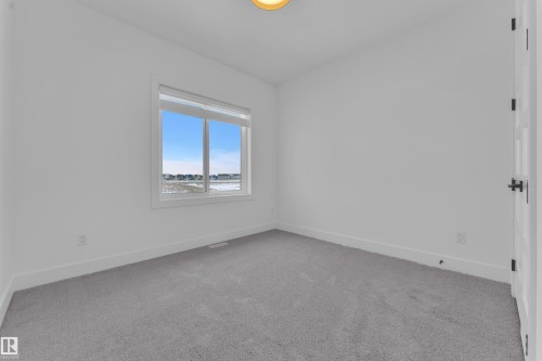 This room features neutral grey carpet, white walls, and a window providing natural light - 110 Eldridge Point(E), St. Albert, AB - Indoor Photo Showing Other Room