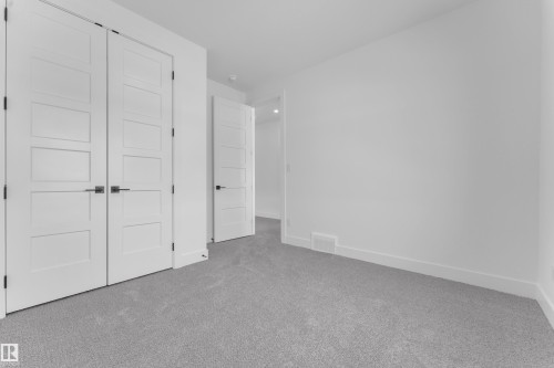 This room features a soft gray carpet, white walls, and white doors with dark hardware - 110 Eldridge Point(E), St. Albert, AB - Indoor Photo Showing Other Room