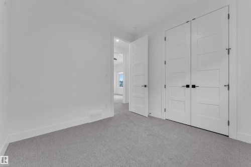 This room features clean white walls, grey carpeting, and white doors with matte black hardware - 110 Eldridge Point(E), St. Albert, AB - Indoor Photo Showing Other Room