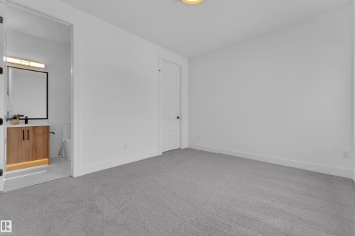 This room features light grey carpet, white walls, and a modern white door with horizontal paneling - 110 Eldridge Point(E), St. Albert, AB - Indoor Photo Showing Other Room
