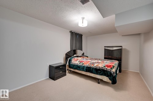 This room features light-colored carpeting, white walls, and a ceiling light fixture - 8507 152B Avenue, Edmonton, AB - Indoor Photo Showing Bedroom
