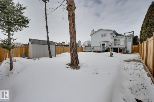 The property features an expansive backyard with a shed, mature trees, and a wooden fence - 8507 152B Avenue, Edmonton, AB - Outdoor