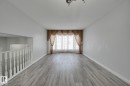 The spacious interior features light-toned flooring, light-colored walls, and a window with elegant drapes - 8507 152B Avenue, Edmonton, AB  - Indoor Photo Showing Other Room 