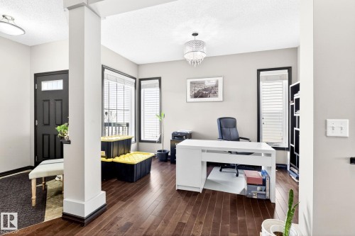 The property features rich hardwood flooring and a black front door with a window insert - 1121 59A Street, Edmonton, AB - Indoor Photo Showing Office