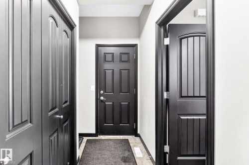 Hallway featuring dark paneled doors and light-colored walls - 1121 59A Street, Edmonton, AB - Indoor Photo Showing Other Room
