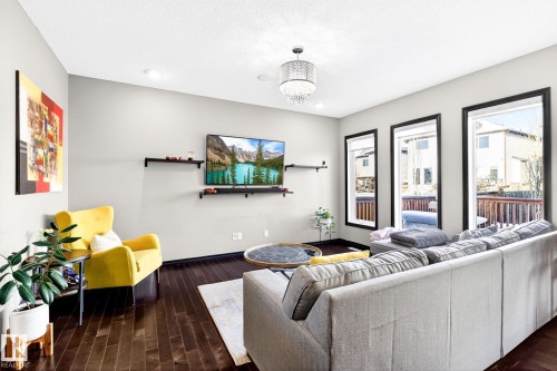 The living area features dark hardwood flooring, recessed lighting, and a decorative chandelier - 1121 59A Street, Edmonton, AB - Indoor Photo Showing Living Room