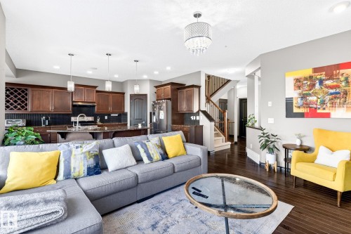 This property features rich hardwood flooring, a kitchen with dark cabinetry and granite countertops, and a staircase with a wooden banister - 1121 59A Street, Edmonton, AB - Indoor Photo Showing Living Room