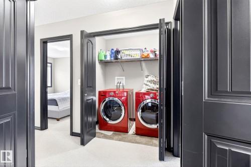 The property features a dedicated laundry area with a washer and dryer, complete with an overhead shelf for storage - 1121 59A Street, Edmonton, AB - Indoor Photo Showing Laundry Room
