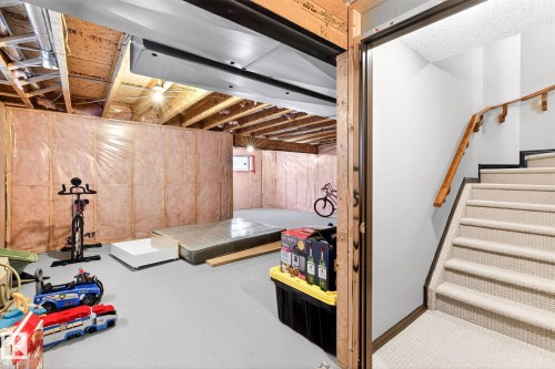 The property features an unfinished basement with exposed ceiling joists and insulation - 1121 59A Street, Edmonton, AB - Indoor Photo Showing Basement