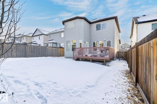 The property features a private backyard with a wooden deck, a wooden fence, and a snow-covered lawn - 1121 59A Street, Edmonton, AB - Outdoor