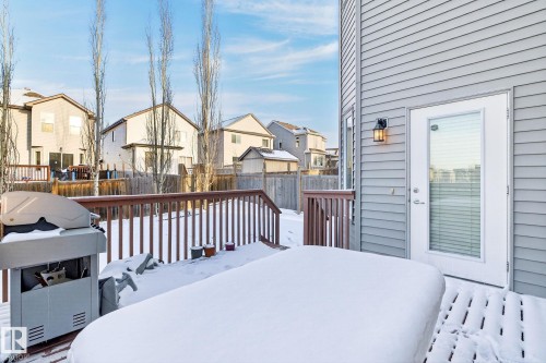 The property features a wooden deck with railing, a back door with a glass panel and horizontal blinds, and exterior siding - 1121 59A Street, Edmonton, AB - Outdoor With Deck Patio Veranda With Exterior