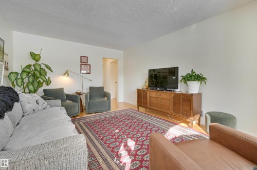 Living area featuring hardwood floors and a decorative area rug - 11116 52 Street Nw, Edmonton, AB - Indoor Photo Showing Living Room