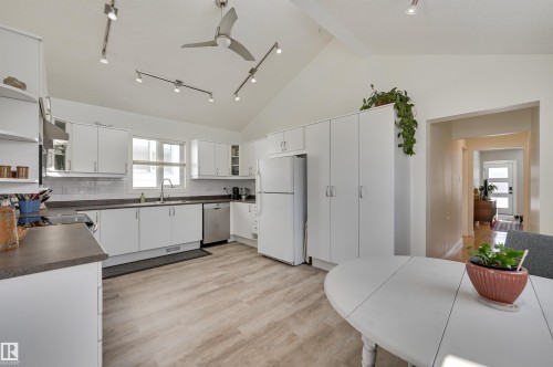 The kitchen features white cabinetry, a white refrigerator, and a stainless steel dishwasher - 11116 52 Street Nw, Edmonton, AB - Indoor Photo Showing Kitchen