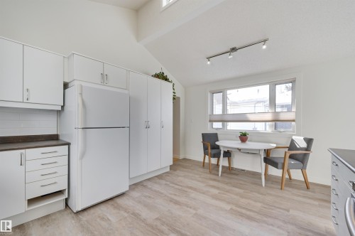 Kitchen with white cabinetry, a white refrigerator, a white tiled backsplash, and light-toned flooring - 11116 52 Street Nw, Edmonton, AB - Indoor
