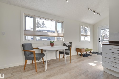 Bright and inviting dining area featuring light-colored flooring, white walls, and track lighting - 11116 52 Street Nw, Edmonton, AB - Indoor Photo Showing Dining Room