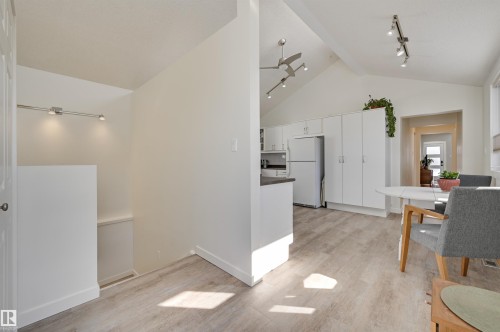 The property features an open-concept living space with vaulted ceilings, light-toned flooring, and track lighting - 11116 52 Street Nw, Edmonton, AB - Indoor