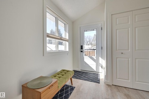 The property features light-colored flooring, white walls, and a window with a view of trees - 11116 52 Street Nw, Edmonton, AB - Indoor Photo Showing Other Room