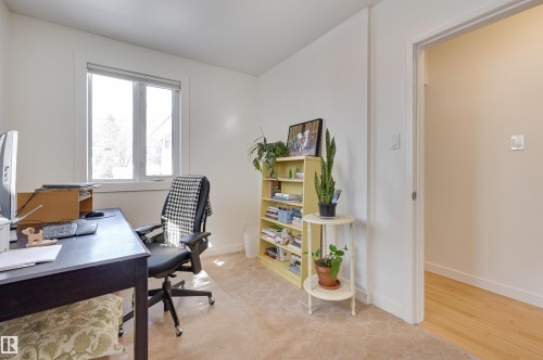 Versatile room with a window, carpeted flooring, and a doorway leading to a space with hardwood flooring - 11116 52 Street Nw, Edmonton, AB - Indoor Photo Showing Office