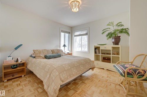 This room features parquet flooring and white walls, creating a bright and open atmosphere - 11116 52 Street Nw, Edmonton, AB - Indoor Photo Showing Bedroom