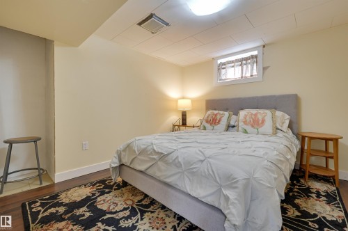 The room features hardwood floors, light-colored walls, and a dropped ceiling - 11116 52 Street Nw, Edmonton, AB - Indoor Photo Showing Bedroom