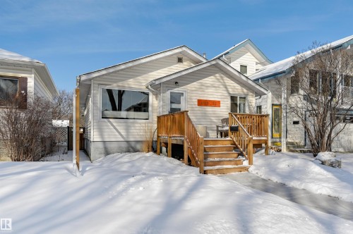 The property features a wood front porch with stairs, white siding, and a visible address number - 11116 52 Street Nw, Edmonton, AB - Outdoor