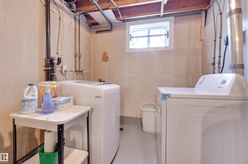 Dedicated laundry area with a window, exposed pipes, and visible ceiling joists - 11116 52 Street Nw, Edmonton, AB - Indoor Photo Showing Laundry Room