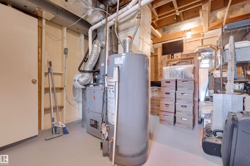 The property features a utility area with a water heater and furnace, exposed ceiling joists, and a painted concrete floor - 11116 52 Street Nw, Edmonton, AB - Indoor Photo Showing Basement