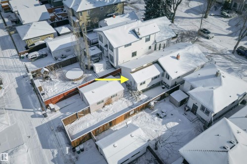 The property features a spacious yard with a red wooden fence, a detached garage, and a round patio area - 11116 52 Street Nw, Edmonton, AB - Outdoor With View