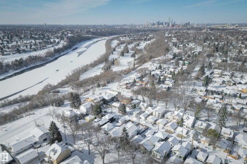 Aerial view of the neighborhood showcasing snow-covered residential roofs, numerous trees, and a frozen river - 11116 52 Street Nw, Edmonton, AB - Outdoor With View