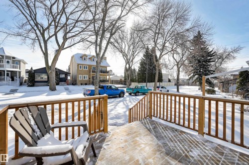The property features a wooden deck with a wooden railing - 11116 52 Street Nw, Edmonton, AB - Outdoor With Deck Patio Veranda