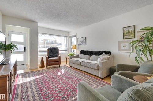 Bright living area featuring hardwood floors and a large window - 11116 52 Street Nw, Edmonton, AB - Indoor Photo Showing Living Room