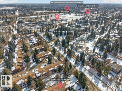 An aerial view showcasing the property's location within a developed neighborhood, featuring a mix of residential structures and abundant mature trees - 91 Hearthstone, Edmonton, AB - Outdoor With View