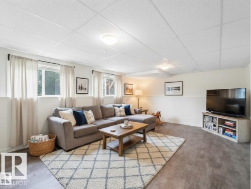 This bright living area features windows that provide natural light, light-colored walls, and durable flooring, creating a comfortable space - 5035 51 Avenue, Lamont, AB - Indoor Photo Showing Living Room