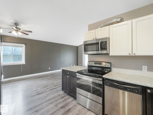 The kitchen features stainless steel appliances, including a microwave, oven, and dishwasher - 5035 51 Avenue, Lamont, AB - Indoor Photo Showing Kitchen