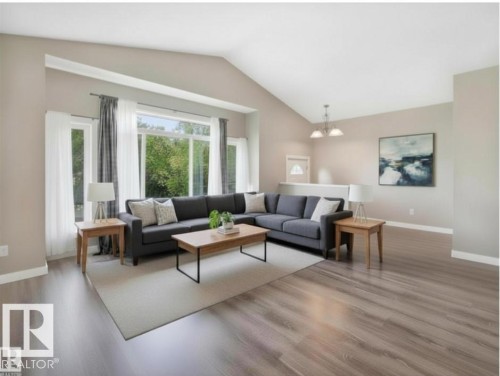 This inviting living area features vaulted ceilings, large windows providing natural light, and light-toned flooring - 5035 51 Avenue, Lamont, AB - Indoor Photo Showing Living Room