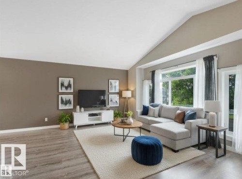 Inviting living space featuring vaulted ceilings, large windows providing natural light, and durable flooring - 5035 51 Avenue, Lamont, AB - Indoor Photo Showing Living Room