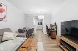 Living room featuring light wood-style floors, a textured ceiling, and a desk - 