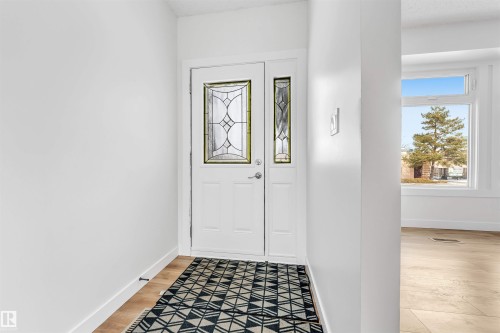 Entryway featuring a white door with decorative glass inserts, a white door frame, and light-toned flooring - 10865 21 Ave, Edmonton, AB - Indoor Photo Showing Other Room