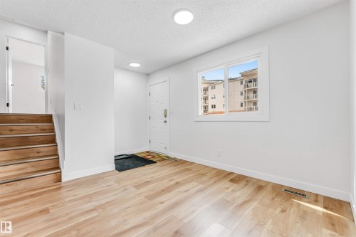 Entryway featuring light wood-look flooring, a white door, and a window providing natural light - 10865 21 Ave, Edmonton, AB - Indoor Photo Showing Other Room