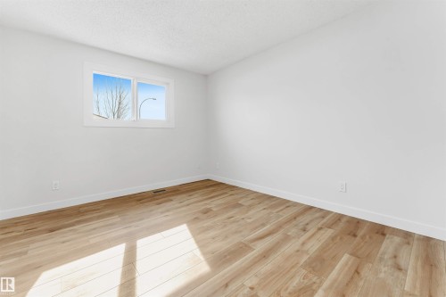 This room features light-colored walls and light-toned flooring, creating a bright and airy atmosphere - 10865 21 Ave, Edmonton, AB - Indoor Photo Showing Other Room